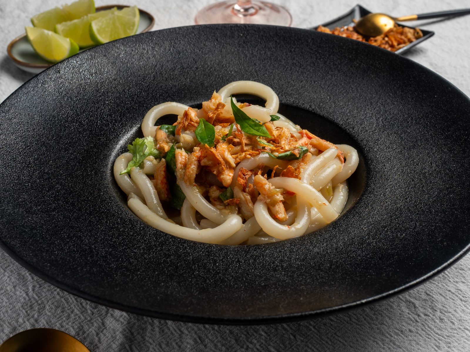 Crab udon in a black bowl with lime